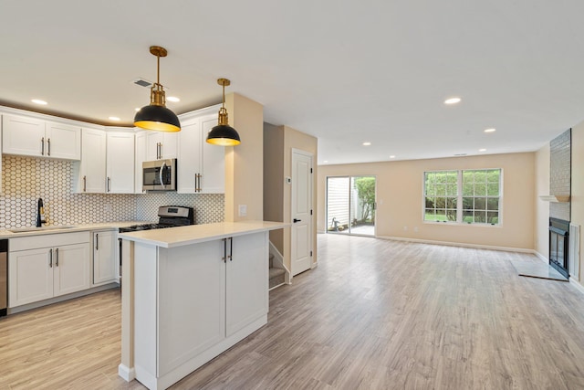 6 Doe Path, Coram, NY 11727 - kitchen with stainless steel microwave, light countertops, tasteful backsplash, light wood-style floors, and open floor plan