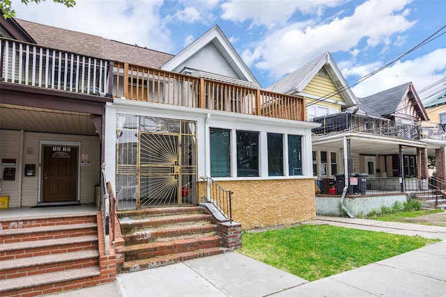 8808 88th St, Woodhaven, NY 11421 - view of front facade with a balcony, covered porch, and a shingled roof