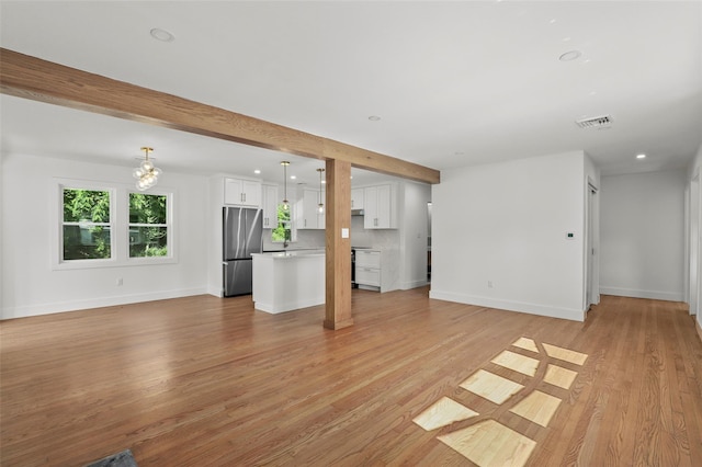 41 Forest Ave, Cortlandt Manor, NY 10567 - unfurnished living room with light wood-style flooring, beam ceiling, a chandelier, and recessed lighting