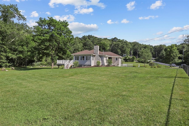 41 Forest Ave, Cortlandt Manor, NY 10567 - view of front facade with a chimney, a wooden deck, and a view of trees