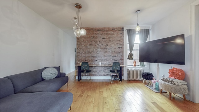 450 W 152nd St Unit 52, New York Manhattan, NY 10031 - living area with radiator heating unit, hardwood / wood-style floors, and brick wall
