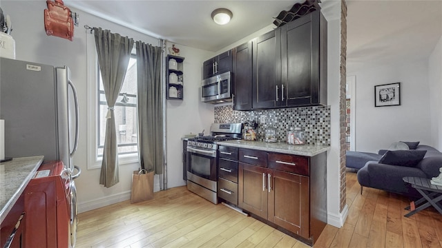 450 W 152nd St Unit 52, New York Manhattan, NY 10031 - kitchen with stainless steel appliances, light wood-style floors, backsplash, and light stone countertops