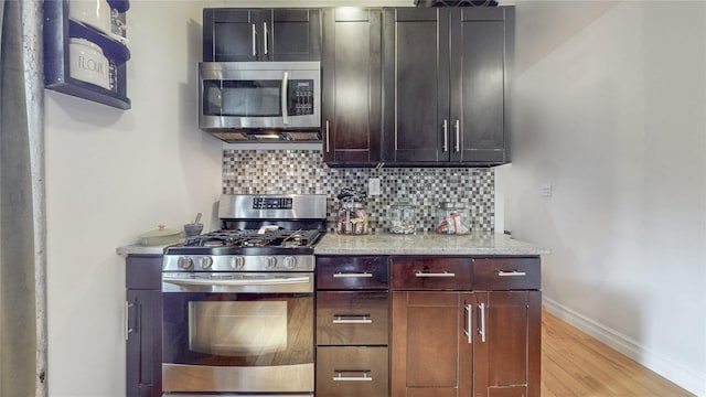 450 W 152nd St Unit 52, New York Manhattan, NY 10031 - kitchen with appliances with stainless steel finishes, tasteful backsplash, light wood-type flooring, and light stone counters