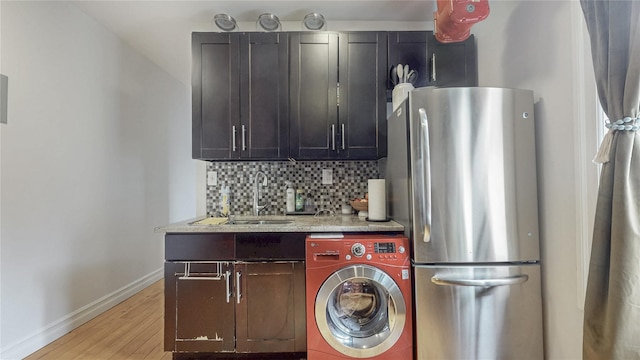 450 W 152nd St Unit 52, New York Manhattan, NY 10031 - kitchen with washer / dryer, freestanding refrigerator, light wood-type flooring, decorative backsplash, and light stone counters