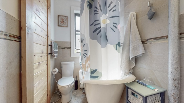 450 W 152nd St Unit 52, New York Manhattan, NY 10031 - bathroom featuring tile walls, a bath, curtained shower, and a wainscoted wall