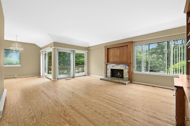 206 Heritage Unit A, Somers, NY 10589 - unfurnished living room featuring light wood-style floors, a chandelier, healthy amount of natural light, a fireplace, and lofted ceiling