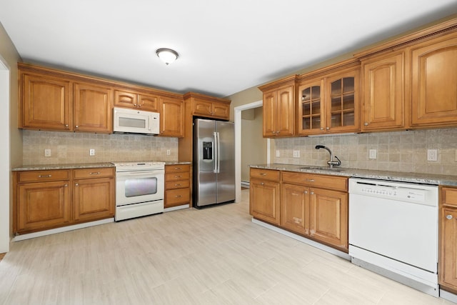 206 Heritage Unit A, Somers, NY 10589 - kitchen featuring white appliances, brown cabinets, tasteful backsplash, and light stone counters