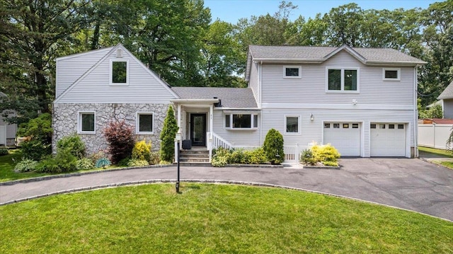 82 Wood Hollow Ln, New Rochelle, NY 10804 - traditional-style home featuring asphalt driveway, a garage, a front yard, and stone siding