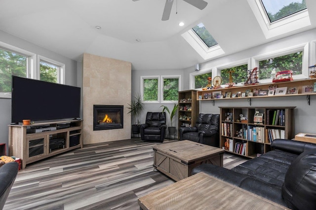 82 Wood Hollow Ln, New Rochelle, NY 10804 - living room featuring a skylight, a fireplace, vaulted ceiling, ceiling fan, and wood finished floors