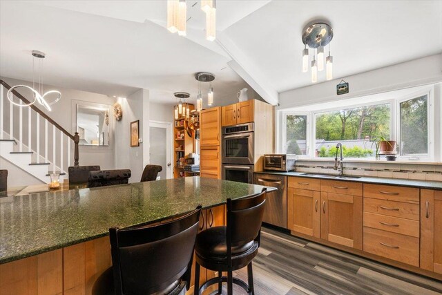 82 Wood Hollow Ln, New Rochelle, NY 10804 - kitchen with a chandelier, stainless steel appliances, a kitchen bar, dark wood-style floors, and pendant lighting