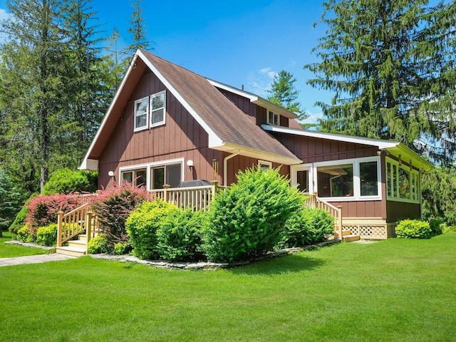 75 Hartung Rd, Eldred, NY 12743 - view of front facade featuring roof with shingles, a front yard, and a sunroom