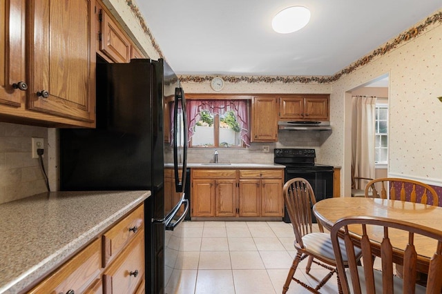 7 Mildred Ct, Nesconset, NY 11767 - kitchen with black appliances, under cabinet range hood, wallpapered walls, brown cabinets, and light countertops