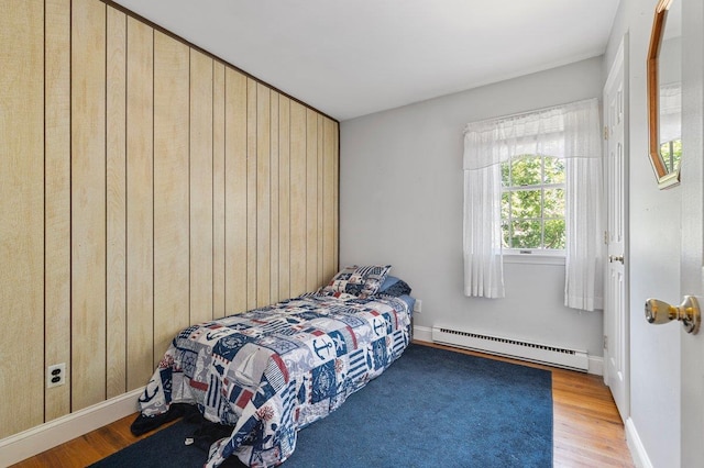 7 Mildred Ct, Nesconset, NY 11767 - bedroom featuring baseboard heating, wood finished floors, and wood walls