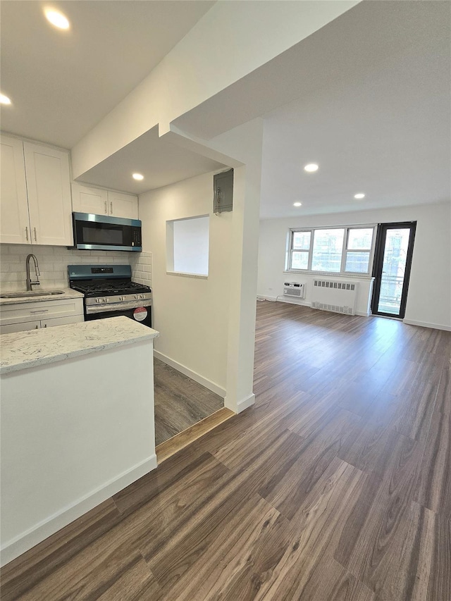 89-40 151st Ave Unit 5F, Howard Beach, NY 11414 - kitchen with appliances with stainless steel finishes, radiator heating unit, open floor plan, dark wood finished floors, and backsplash