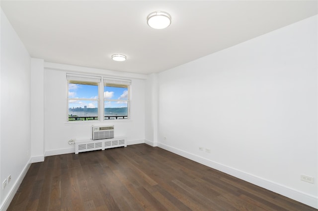 5700 Arlington Ave Unit 12T, Bronx, NY 10471 - unfurnished room featuring dark wood-style flooring, radiator, and a wall unit AC