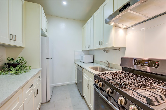 111-39 76th Rd Unit E2, Forest Hills, NY 11375 - kitchen featuring appliances with stainless steel finishes, wall chimney range hood, light countertops, light tile patterned floors, and white cabinets