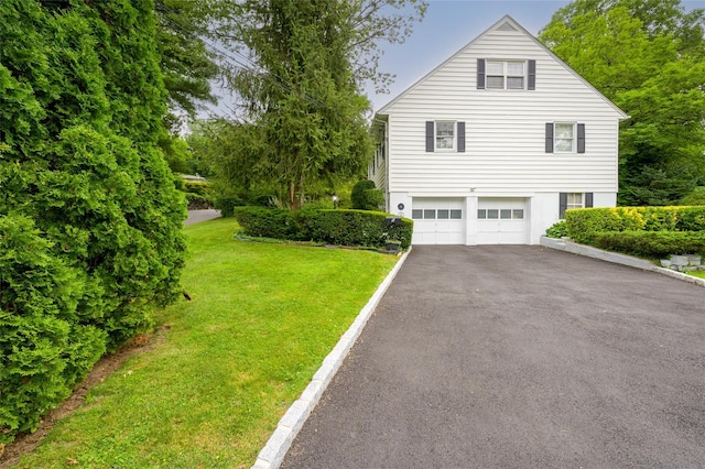9 Martin Rd, Yonkers, NY 10701 - view of side of property with asphalt driveway, a garage, and a lawn