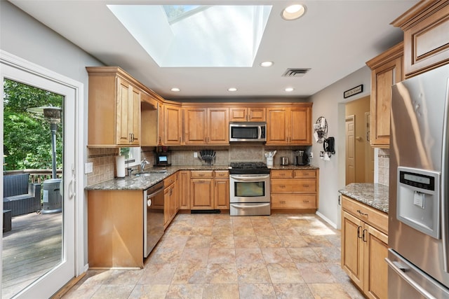 27A Claremont Ln, Suffern, NY 10901 - kitchen featuring stainless steel appliances, decorative backsplash, stone counters, recessed lighting, and a skylight