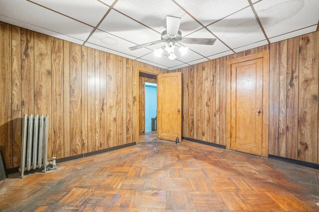 2117 38th St, Astoria, NY 11105 - unfurnished room featuring radiator heating unit, ceiling fan, and wood walls