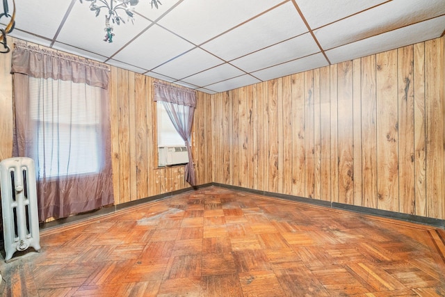 2117 38th St, Astoria, NY 11105 - empty room featuring radiator, cooling unit, and wood walls