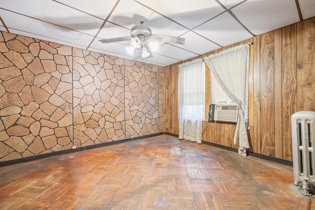 2117 38th St, Astoria, NY 11105 - unfurnished room featuring radiator, wood walls, a ceiling fan, and cooling unit