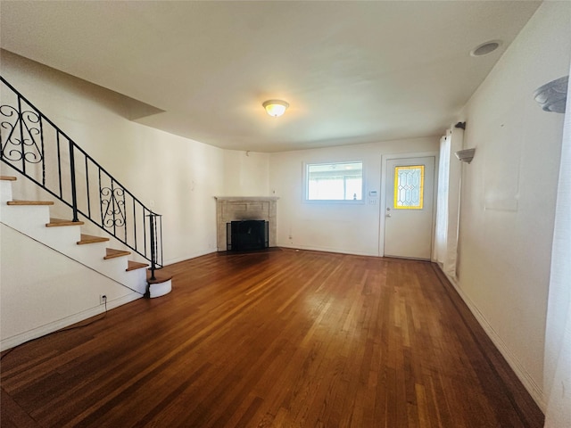 384 Hawthorne Ave, Yonkers, NY 10705 - unfurnished living room with wood finished floors, a fireplace with flush hearth, and stairs