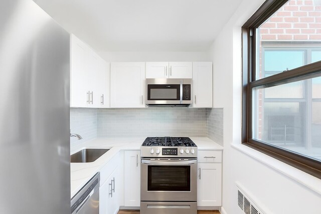 1165 E 53rd Unit Z7Z, Brooklyn, NY 11234 - kitchen with stainless steel appliances, decorative backsplash, and white cabinetry