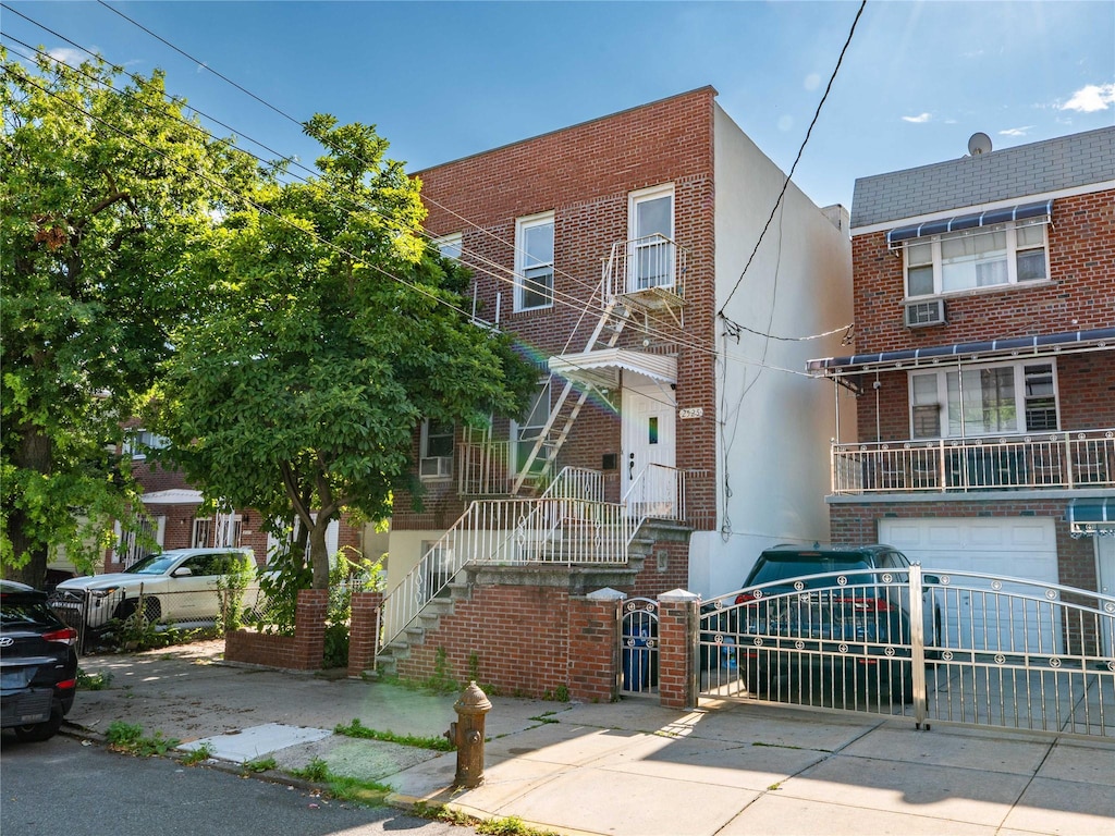 2525 Radcliff Ave, Bronx, NY 10469 - multi unit property with brick siding, concrete driveway, a garage, stucco siding, and a gate