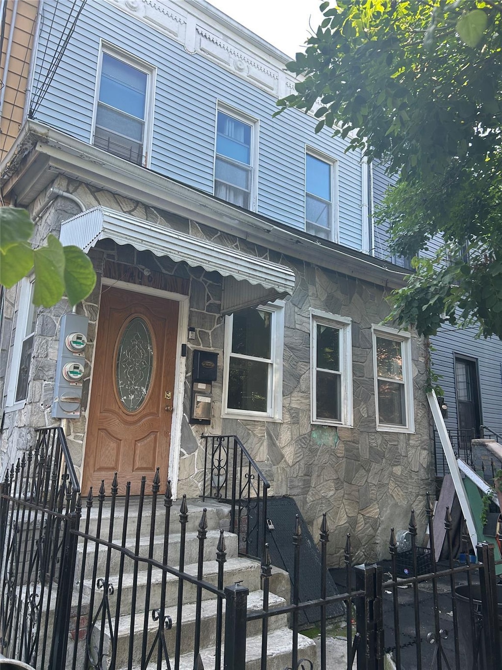 406 Chestnut St, Brooklyn, NY 11208 - view of front of property with stone siding and a fenced front yard