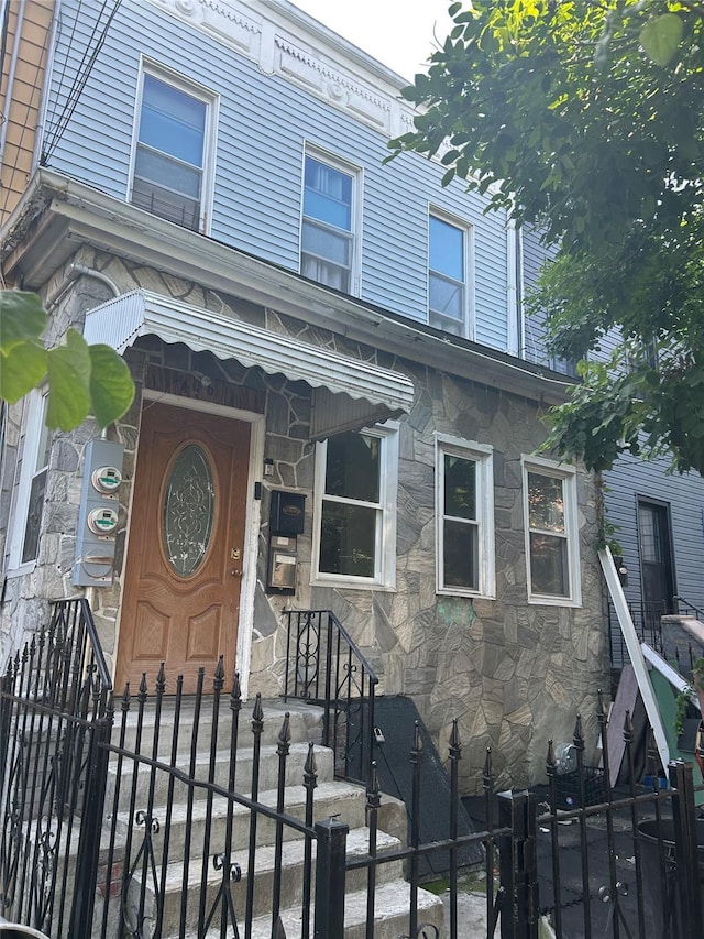 406 Chestnut St, Brooklyn, NY 11208 - view of front of property with stone siding and a fenced front yard