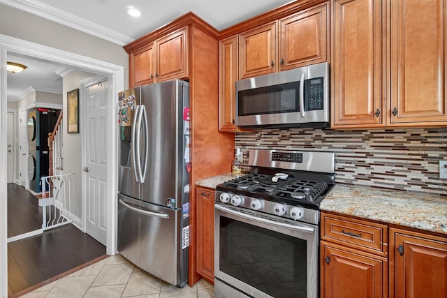 1004 Balcom Ave, Bronx, NY 10465 - kitchen with stainless steel appliances, stacked washer and clothes dryer, ornamental molding, brown cabinets, and tasteful backsplash
