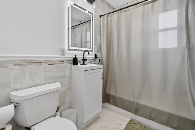 1004 Balcom Ave, Bronx, NY 10465 - full bathroom featuring vanity, shower / bath combination with curtain, marble look tiles, and a wainscoted wall