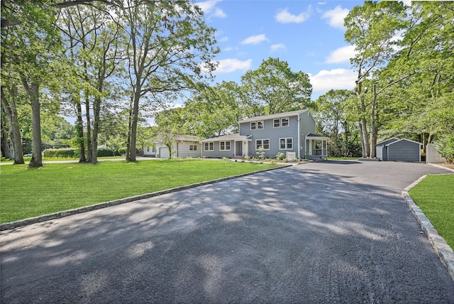 70 Robinson Ave, Brookhaven, NY 11763 - view of front of home with an outdoor structure, a front lawn, and asphalt driveway