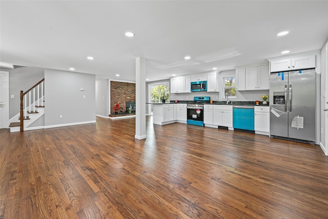 70 Robinson Ave, Brookhaven, NY 11763 - kitchen featuring stainless steel appliances, dark countertops, recessed lighting, dark wood finished floors, and white cabinets