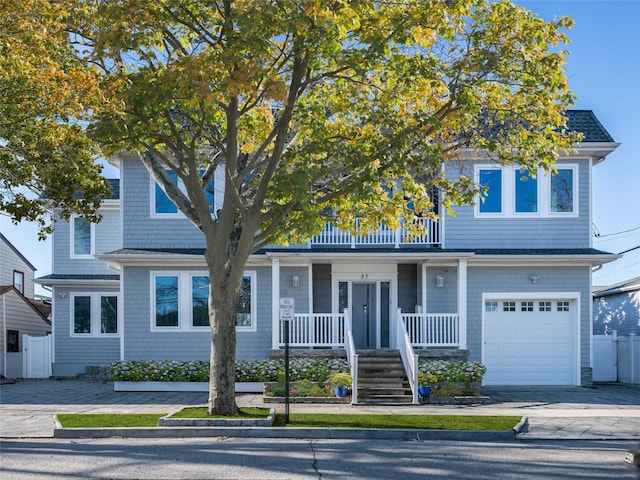 85 Erie Ave, Atlantic Beach, NY 11509 - shingle-style home with covered porch, a garage, a balcony, driveway, and stairway