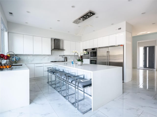 85 Erie Ave, Atlantic Beach, NY 11509 - kitchen featuring wall chimney range hood, a kitchen island with sink, modern cabinets, decorative backsplash, and recessed lighting