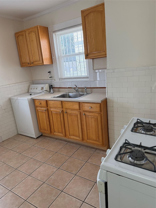 9030 202nd St, Hollis, NY 11423 - kitchen with washer / clothes dryer, white range with gas stovetop, light countertops, tile walls, and light tile patterned floors
