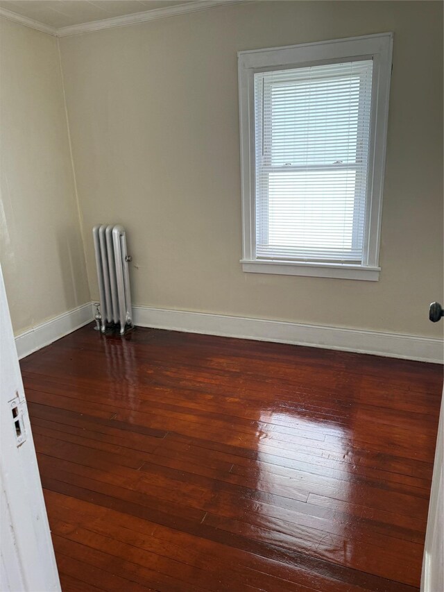 9030 202nd St, Hollis, NY 11423 - empty room with radiator, ornamental molding, and dark wood-type flooring