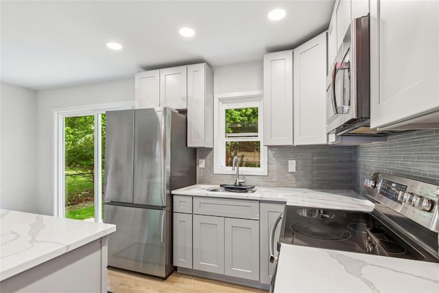 5 Coolidge Rd, Hampton Bays, NY 11946 - kitchen featuring stainless steel appliances, backsplash, recessed lighting, and light stone counters