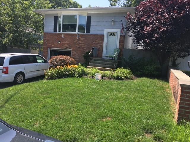 10 Talman Pl, Dix Hills, NY 11746 - view of front facade featuring brick siding and a front lawn