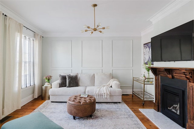 24 8th St, Hudson, NY 12534 - living area featuring ornamental molding, healthy amount of natural light, wood finished floors, a chandelier, and a glass covered fireplace