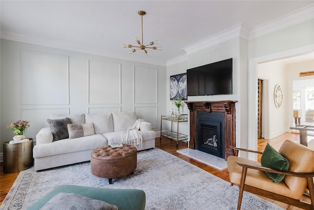 24 8th St, Hudson, NY 12534 - living area with ornamental molding, wood finished floors, a chandelier, a fireplace with raised hearth, and a decorative wall