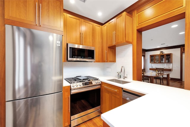 181 Walnut St, Lynbrook, NY 11563 - kitchen featuring appliances with stainless steel finishes, light countertops, backsplash, light wood finished floors, and a peninsula