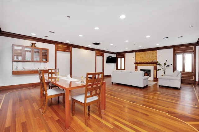 181 Walnut St, Lynbrook, NY 11563 - dining space featuring ornamental molding, light wood finished floors, recessed lighting, and a fireplace