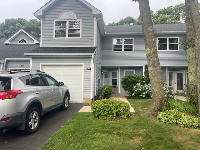 82 Lakeview Dr, Manorville, NY 11949 - view of front facade with asphalt driveway, an attached garage, and a front yard