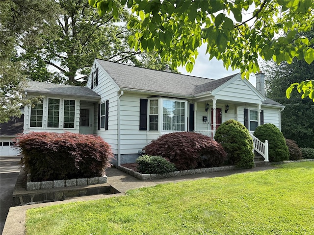 63 Washburns Ln, Stony Point, NY 10980 - view of front facade featuring a chimney, a front yard, a garage, roof with shingles, and concrete driveway