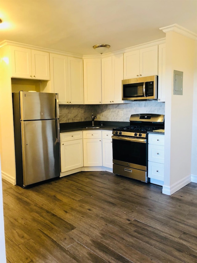 20 Secor Unit 5L, Yonkers, NY 10704 - kitchen featuring stainless steel appliances, dark countertops, white cabinets, dark wood-style floors, and ornamental molding