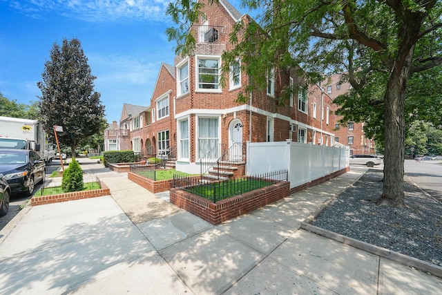 6851 Clyde St, Forest Hills, NY 11375 - view of front of house featuring brick siding and a fenced front yard