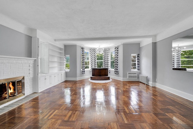 6851 Clyde St, Forest Hills, NY 11375 - unfurnished living room with radiator heating unit, a fireplace, a textured ceiling, a chandelier, and a wall mounted AC