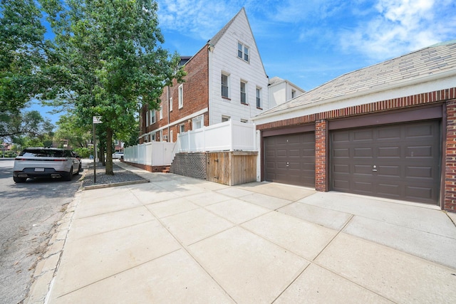 6851 Clyde St, Forest Hills, NY 11375 - view of home's exterior with concrete driveway, brick siding, and a garage